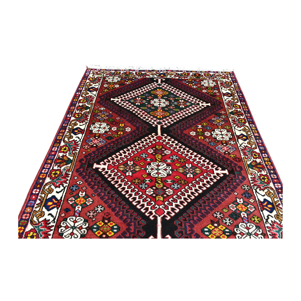 Field detail of Persian Shiraz runner showing linked dark green and red diamond medallions beside the floral side border