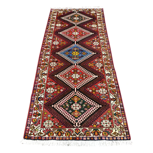 Full view of vintage Persian Shiraz runner rug with five vertically aligned diamond medallions on a deep red field, 302 x 125 cm