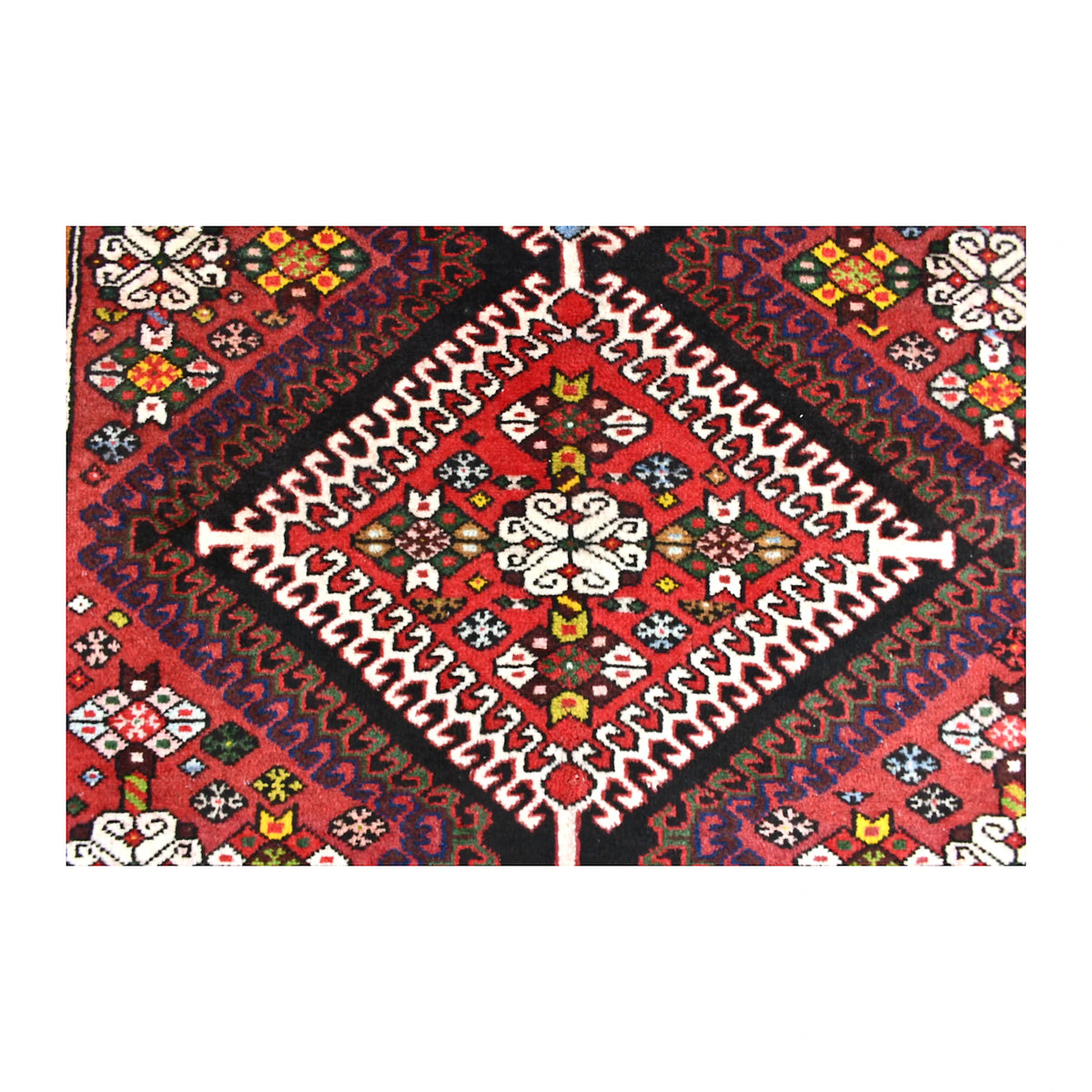 Close-up of red diamond medallion with ivory stepped outlines and small multicoloured geometric motifs