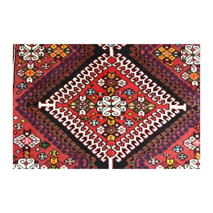 Close-up of red diamond medallion with ivory stepped outlines and small multicoloured geometric motifs