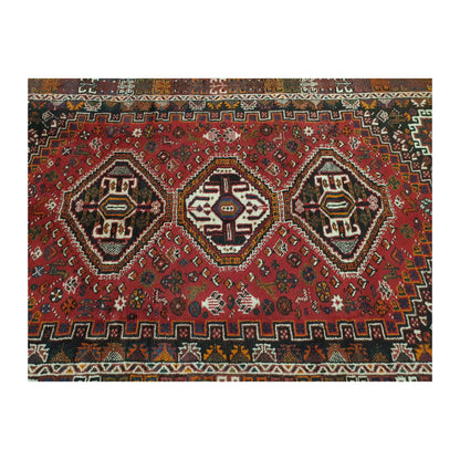 Field detail of Persian Shiraz rug showing three geometric medallions surrounded by small multicolour motifs