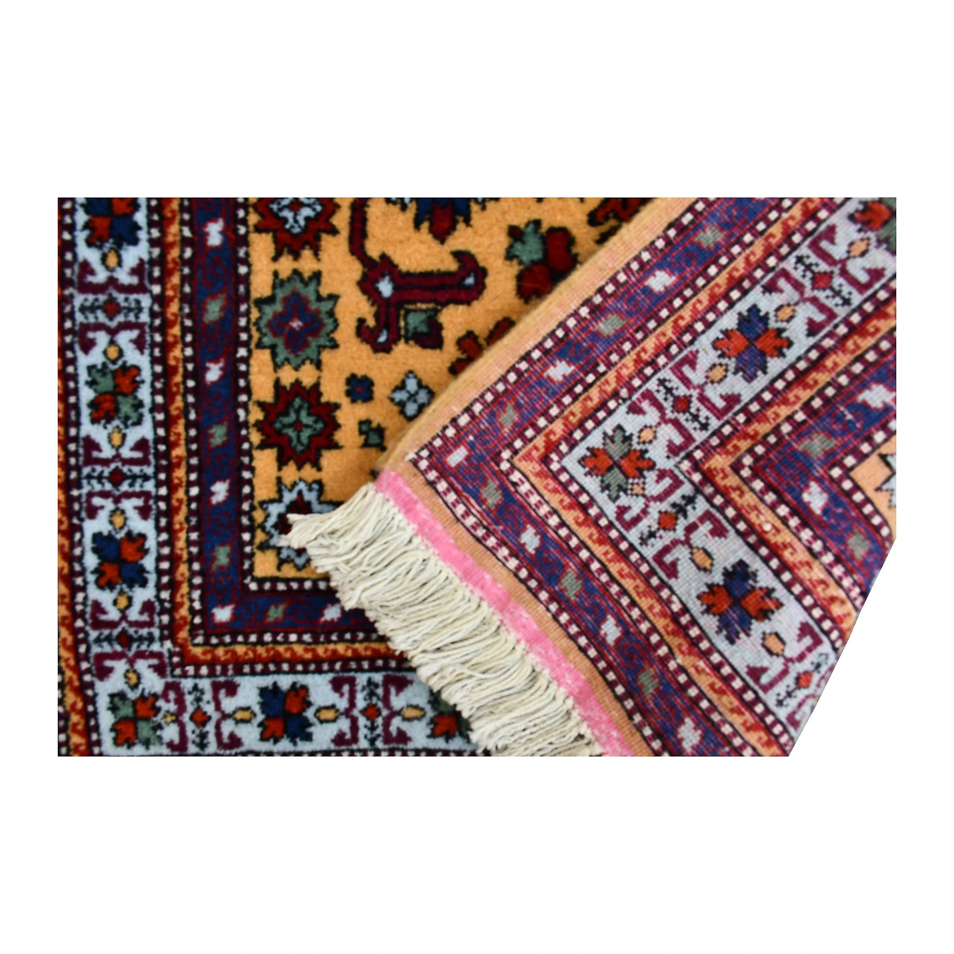 Folded corner of Persian Veramin rug showing the patterned face, reverse weave and fringed finishing edge