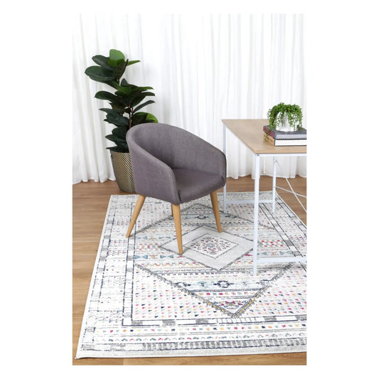 Provence grey pink medallion rug styled with chair and indoor plant