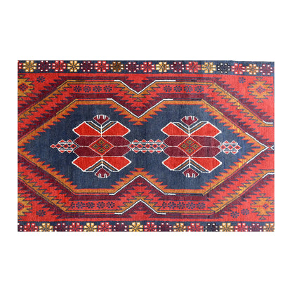 Field detail of Baluchi rug showing two geometric medallions within a red and navy angular design