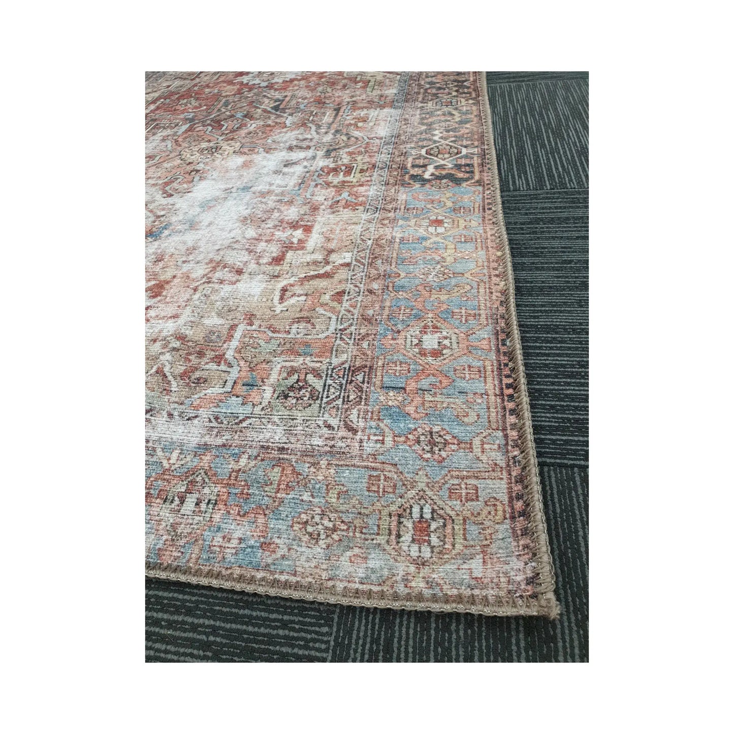 Close-up of rust blue cotton rug corner with ornamental border detail