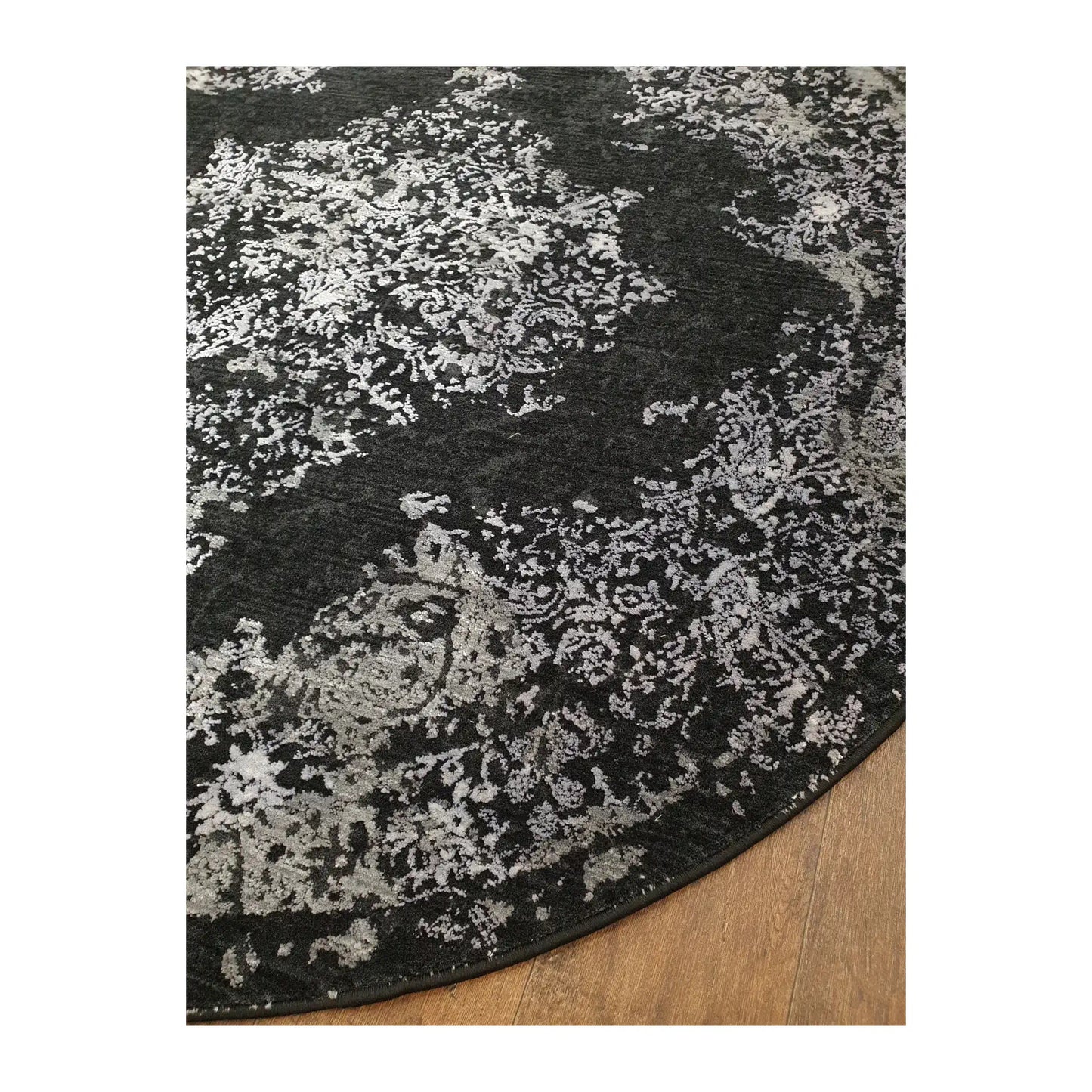 Angled detail of silver and charcoal round rug showing pattern and edge finish, 160 cm