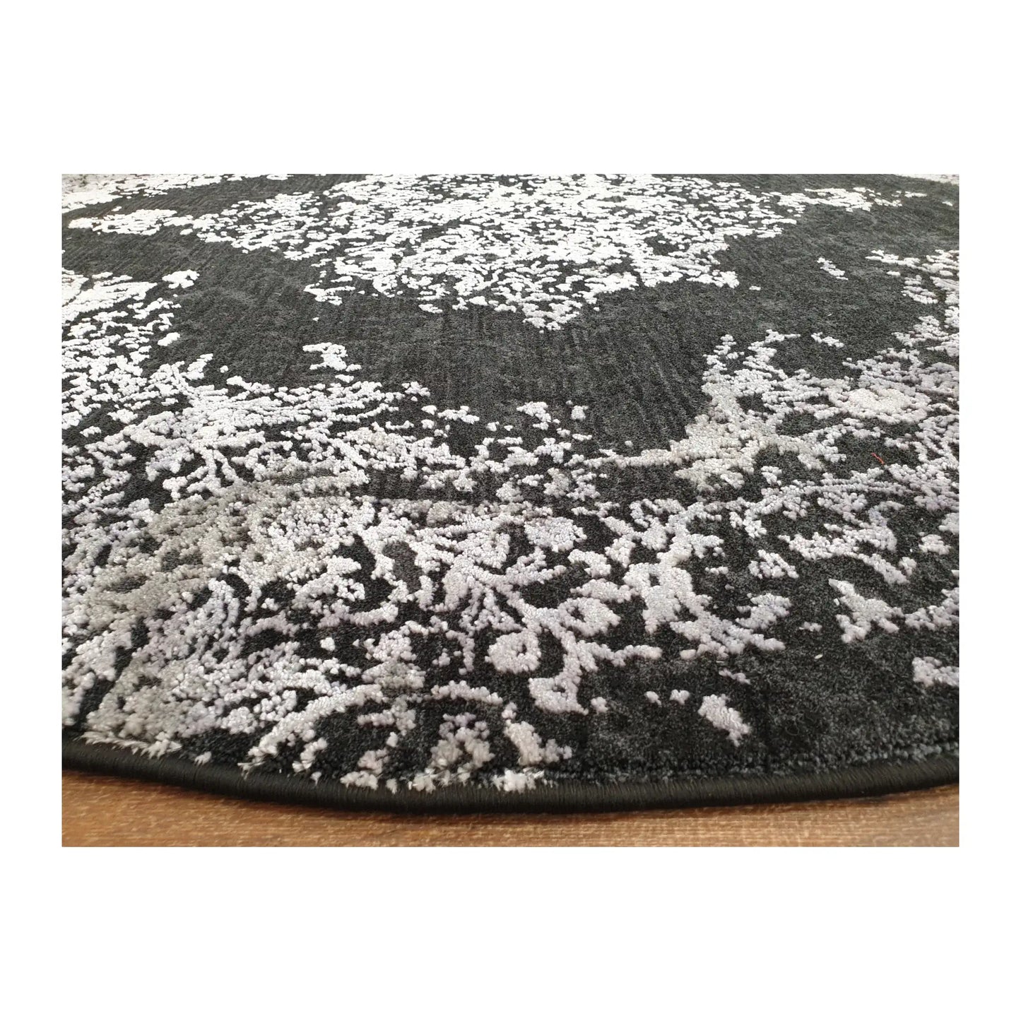 Low-angle close-up of silver and charcoal round rug showing surface texture and patterned finish, 160 cm