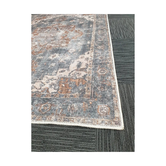 Close-up of slate blue rust cotton rug corner with ornamental border detail