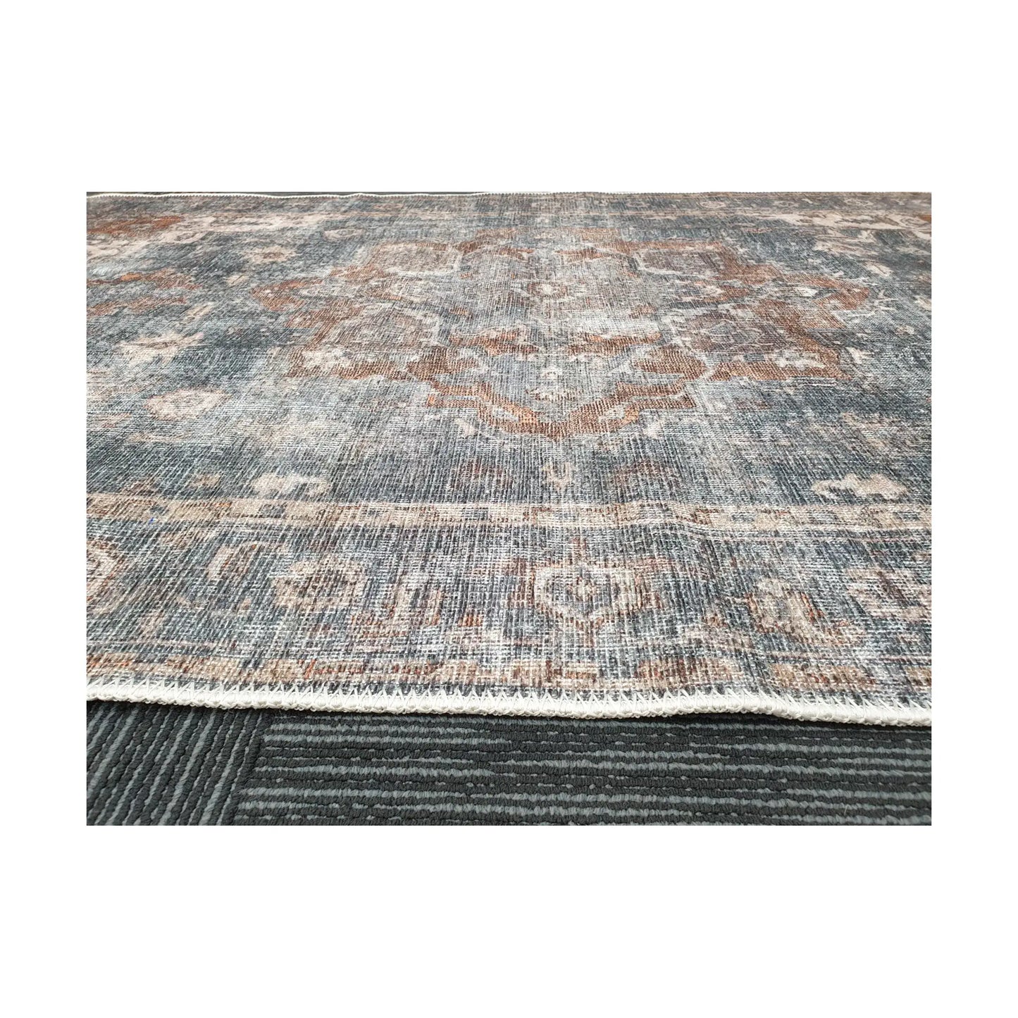 Low-angle close-up of slate blue rust cotton rug edge and woven surface texture