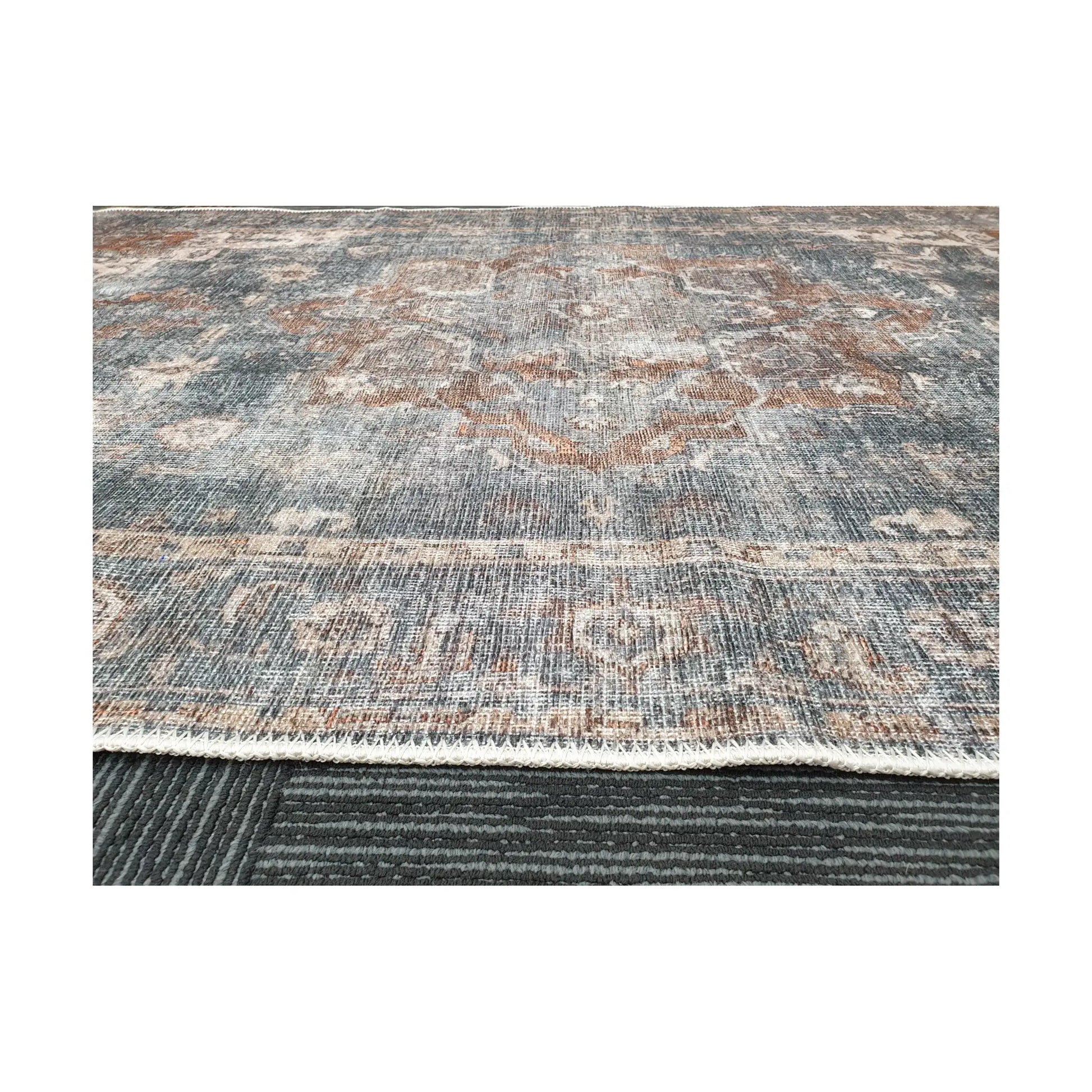 Low-angle close-up of slate blue rust cotton rug edge and woven surface texture