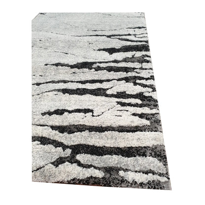 Edge detail of Stella Grey Runner Rug showing textured grey surface and black abstract pattern