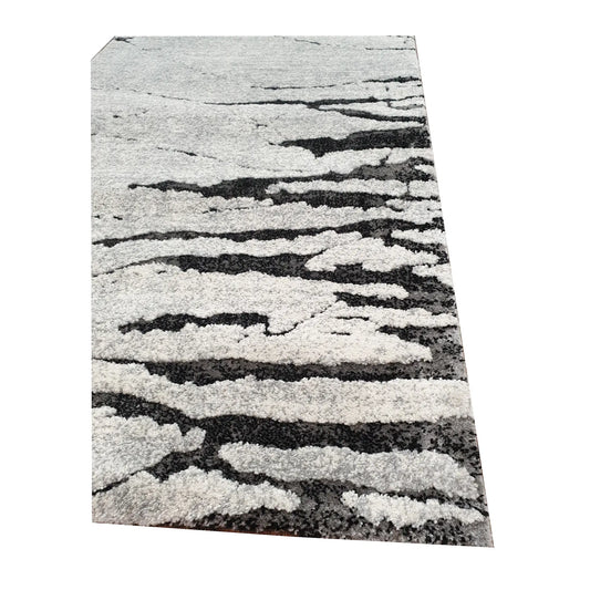 Edge detail of Stella Grey Runner Rug showing textured grey surface and black abstract pattern