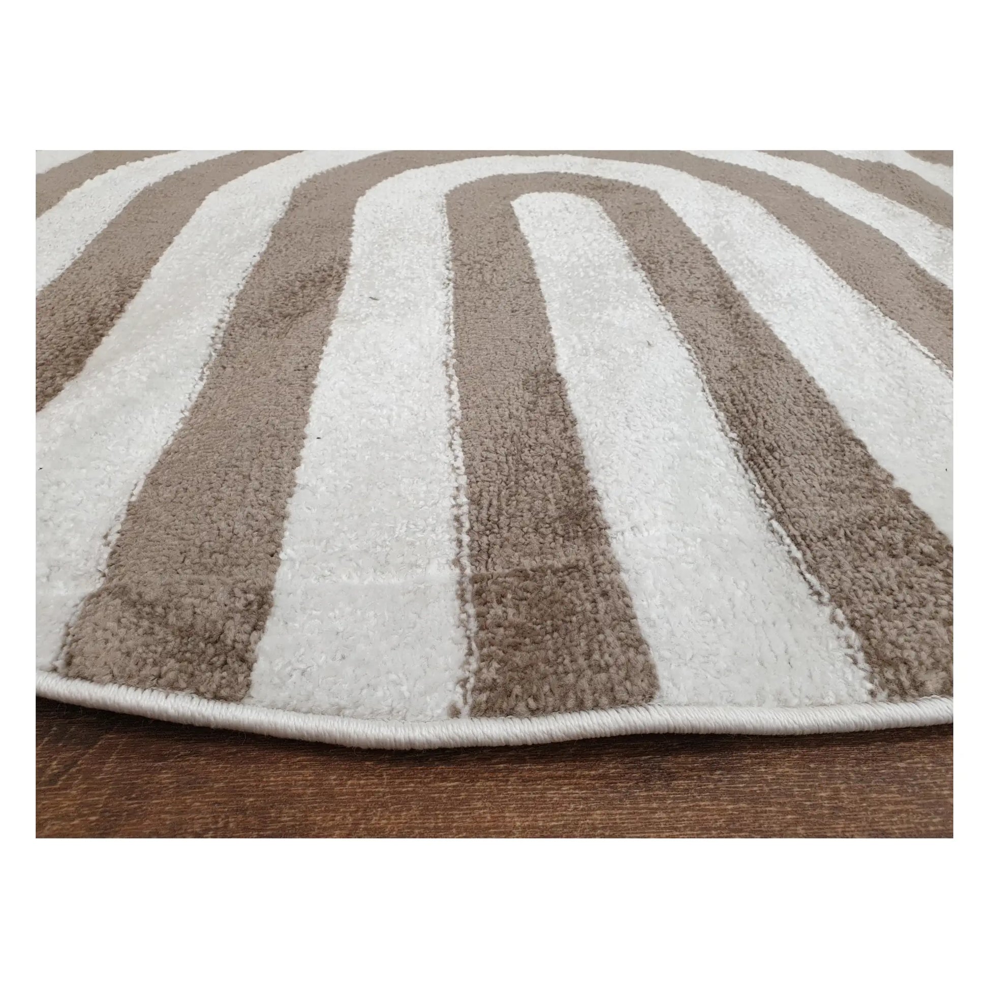 Low-angle close-up of taupe round rug showing surface texture and curved stripe design, 160 cm