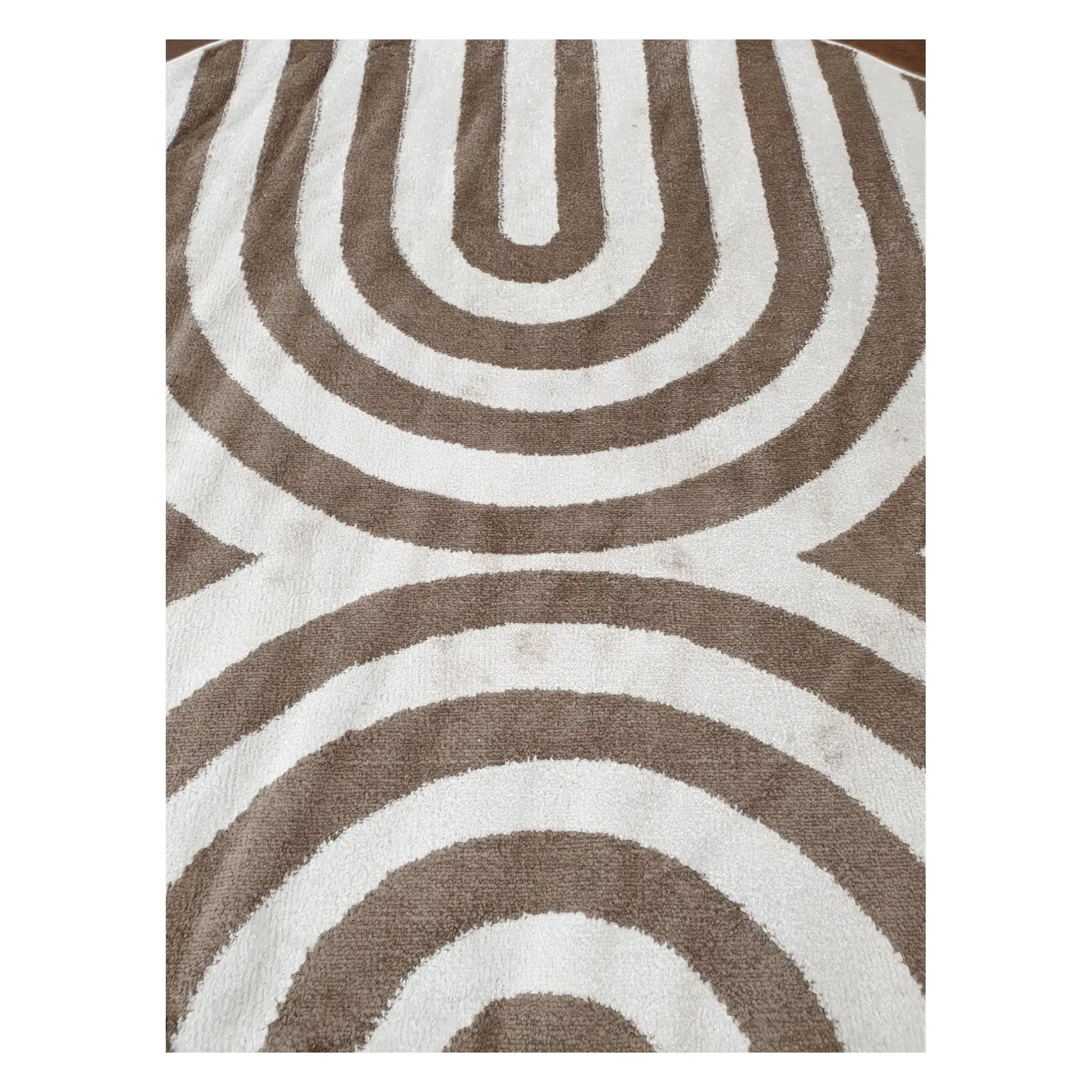 Close-up of taupe and ivory round rug with modern curved stripe pattern, 160 cm