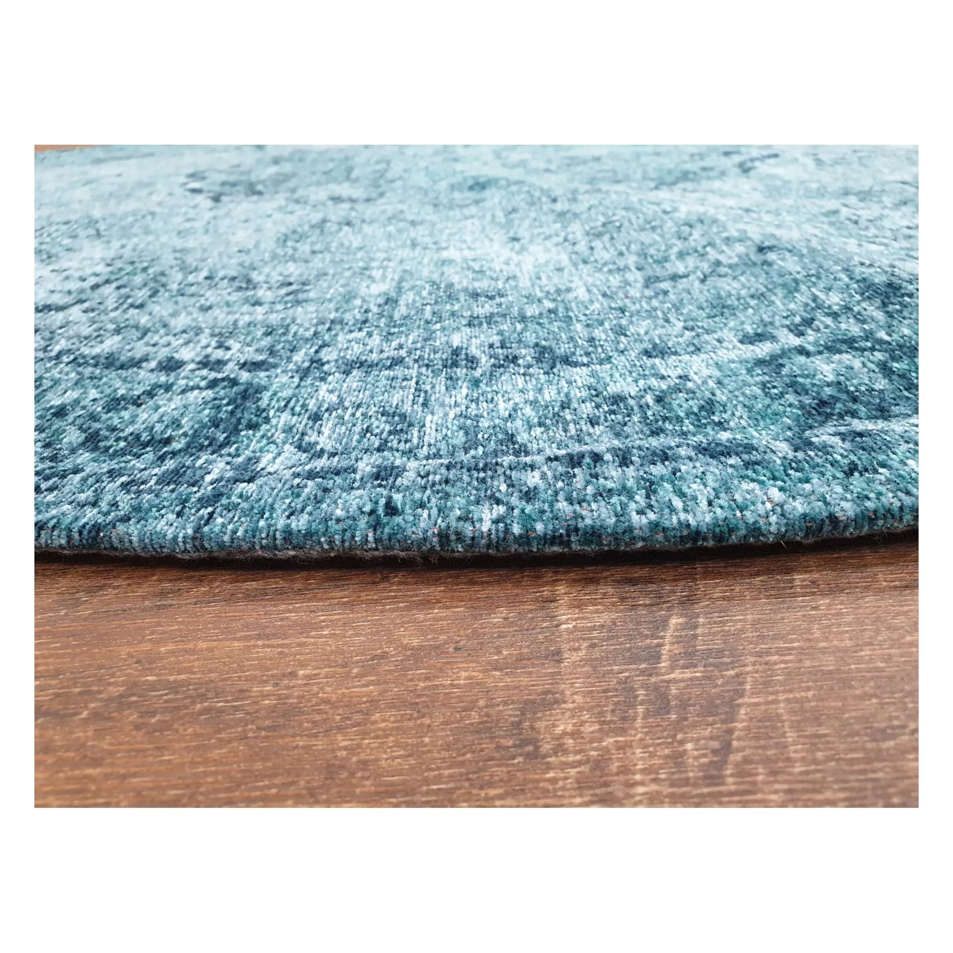 Close-up of teal round chenille polyester rug showing texture and distressed pattern detail, 160 cm