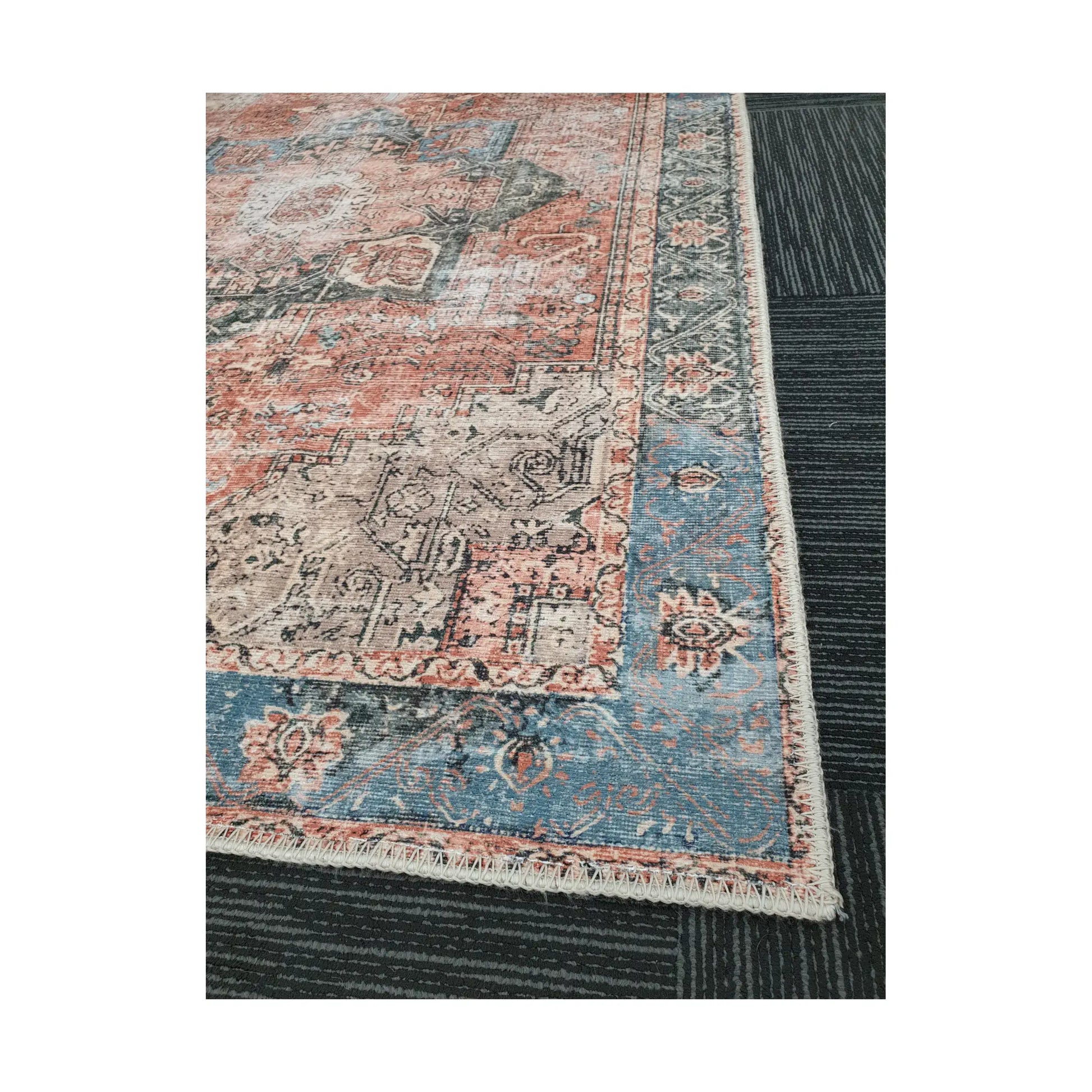 Close-up of terracotta blue cotton rug corner with ornamental border detail