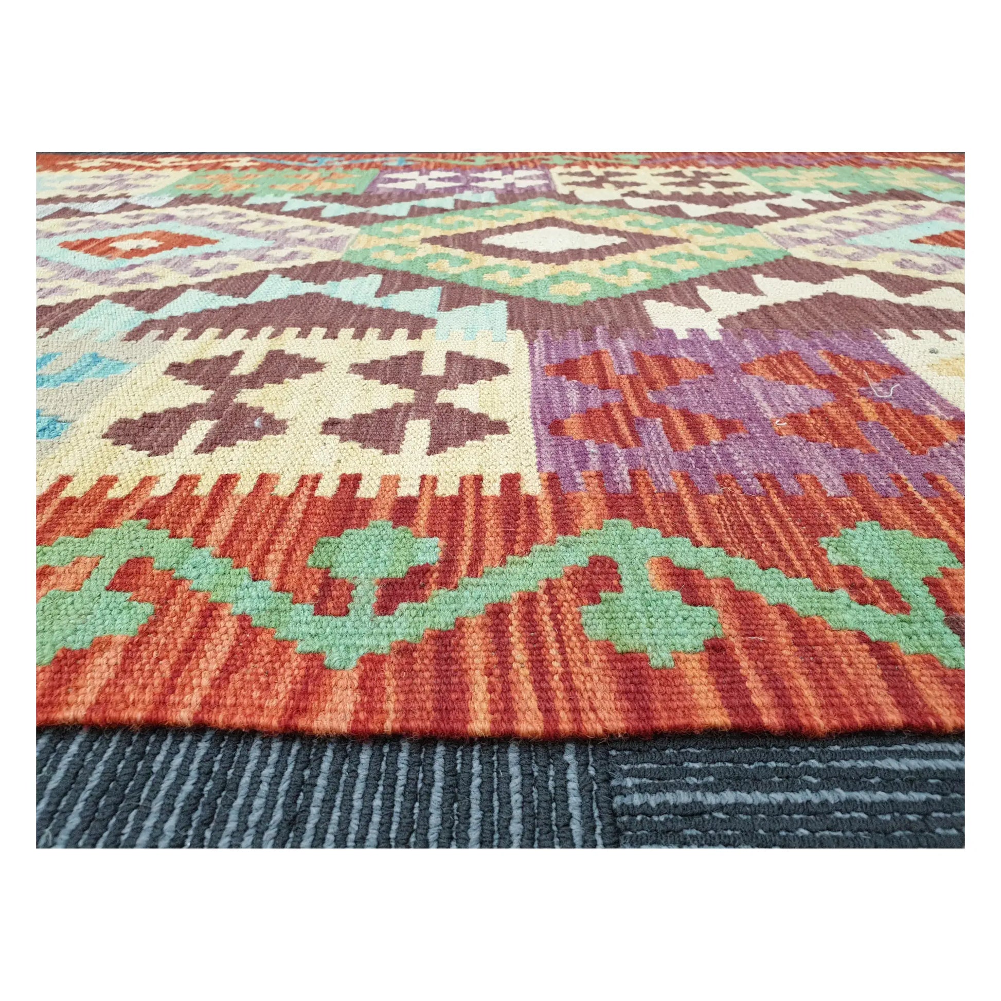 Low-angle close-up of Afghan Chobi Kilim showing wool flatweave texture and multicolour tribal pattern, 143 x 107 cm