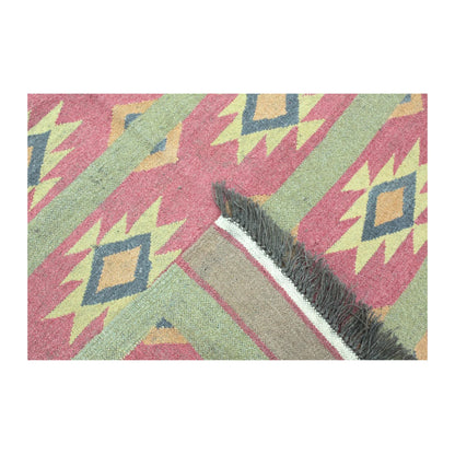 Folded reverse-weave and fringe detail of Turkish Kilim wool rug with sage green border and dusty pink geometric field, 200 x 144 cm