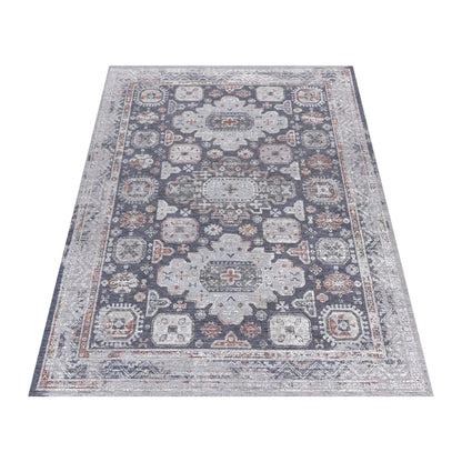 Angled full view of the charcoal Kazaki rug with layered grey borders and muted rust accents