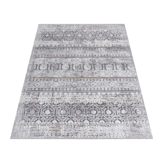 Angled full view of the Turkish Zagros rug showing layered grey geometric stripes and rust accents