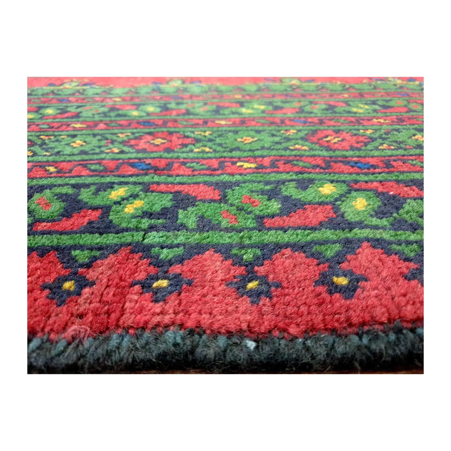 Close-up of Afghan Turkoman wool rug showing floral border motifs and dense pile texture