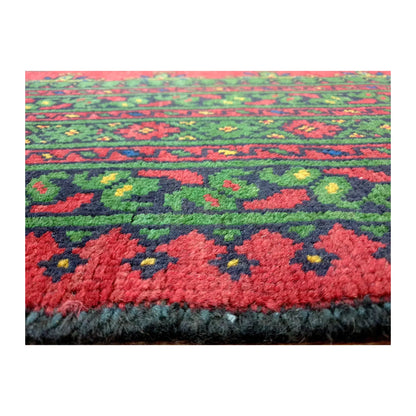 Close-up of Afghan Turkoman wool rug showing floral border motifs and dense pile texture