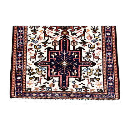 Fringe-end detail of vintage Afshar rug showing a navy stepped medallion surrounded by stylised animals and ducks on ivory