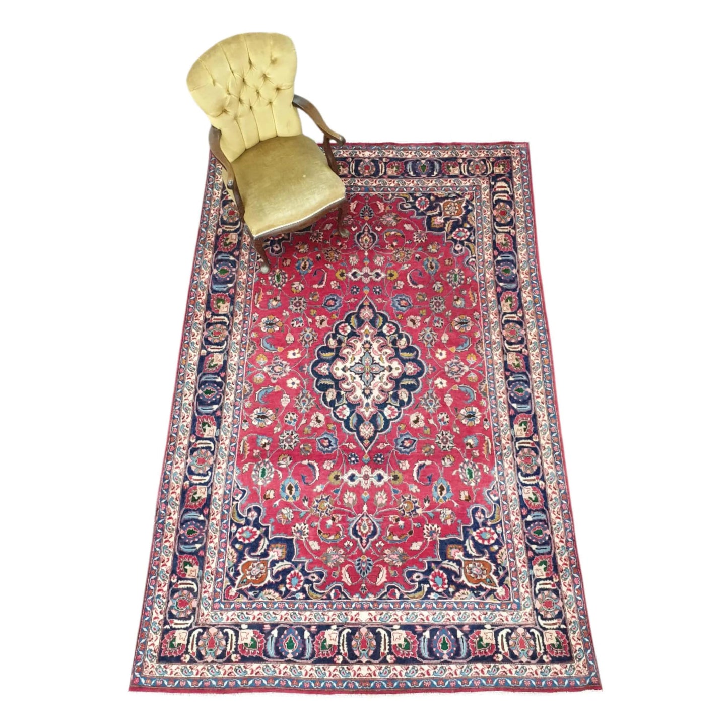 Styled full view of Vintage Mashad wool rug with rose-red field, central medallion and chair, 290 x 186 cm