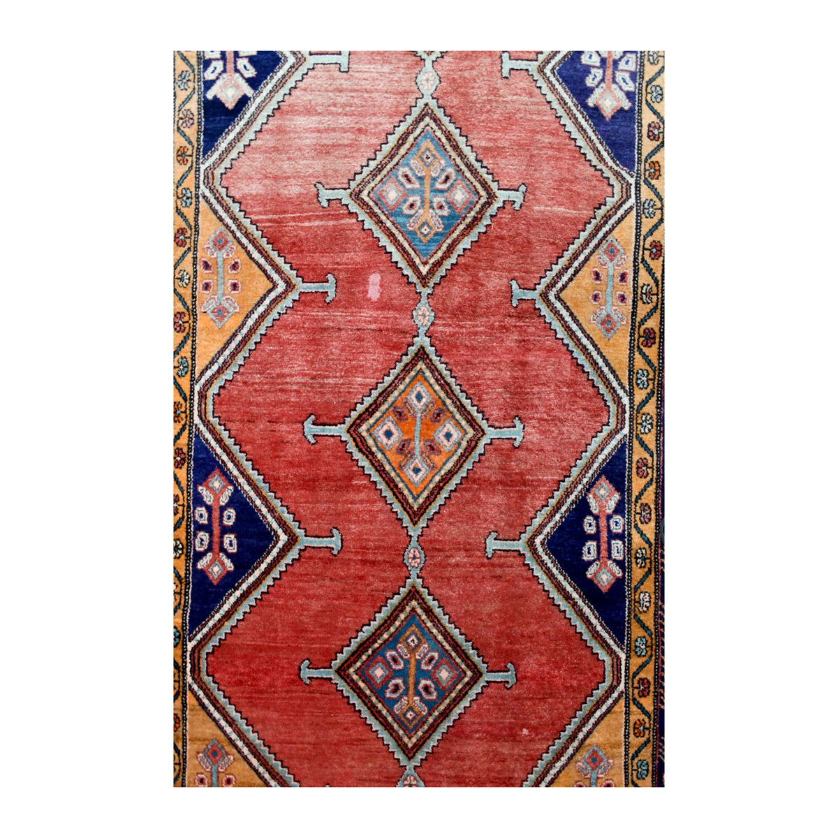 Field detail of Persian Afshar rug showing three linked hooked-diamond medallions across a weathered brick-red ground