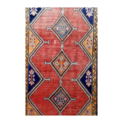 Field detail of Persian Afshar rug showing three linked hooked-diamond medallions across a weathered brick-red ground