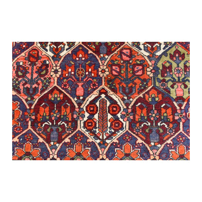Detailed view of Bakhtiari Khesti field showing stylised flowering trees and vase motifs within burgundy, orange, indigo and ivory panels