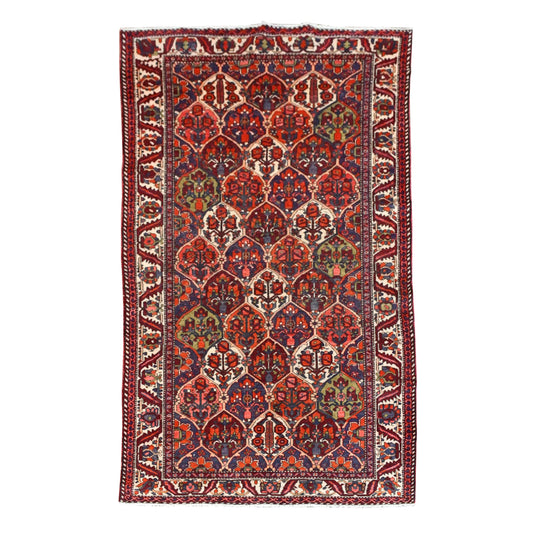 Full view of vintage Persian Bakhtiari hand-knotted wool rug with pointed multicolour garden panels and a wide ivory border, 297 x 159 cm