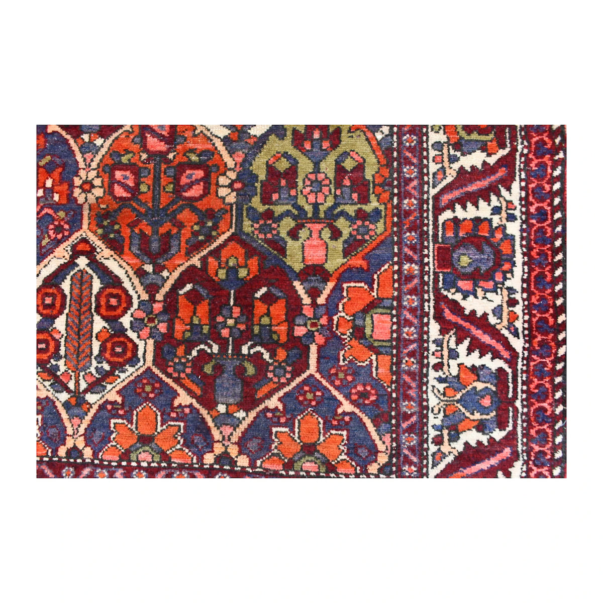 Close-up of vintage Bakhtiari rug showing pointed garden compartments, a green flowering-vase panel and ivory floral border
