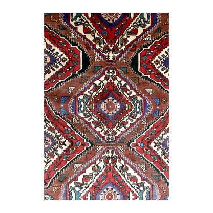 Field detail of vintage Bakhtiari rug showing layered diamond medallions between rust-brown chevrons and ivory spaces