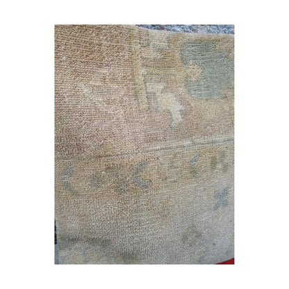 Detailed view of softly faded beige wool pile with geometric and linear Persian pattern traces