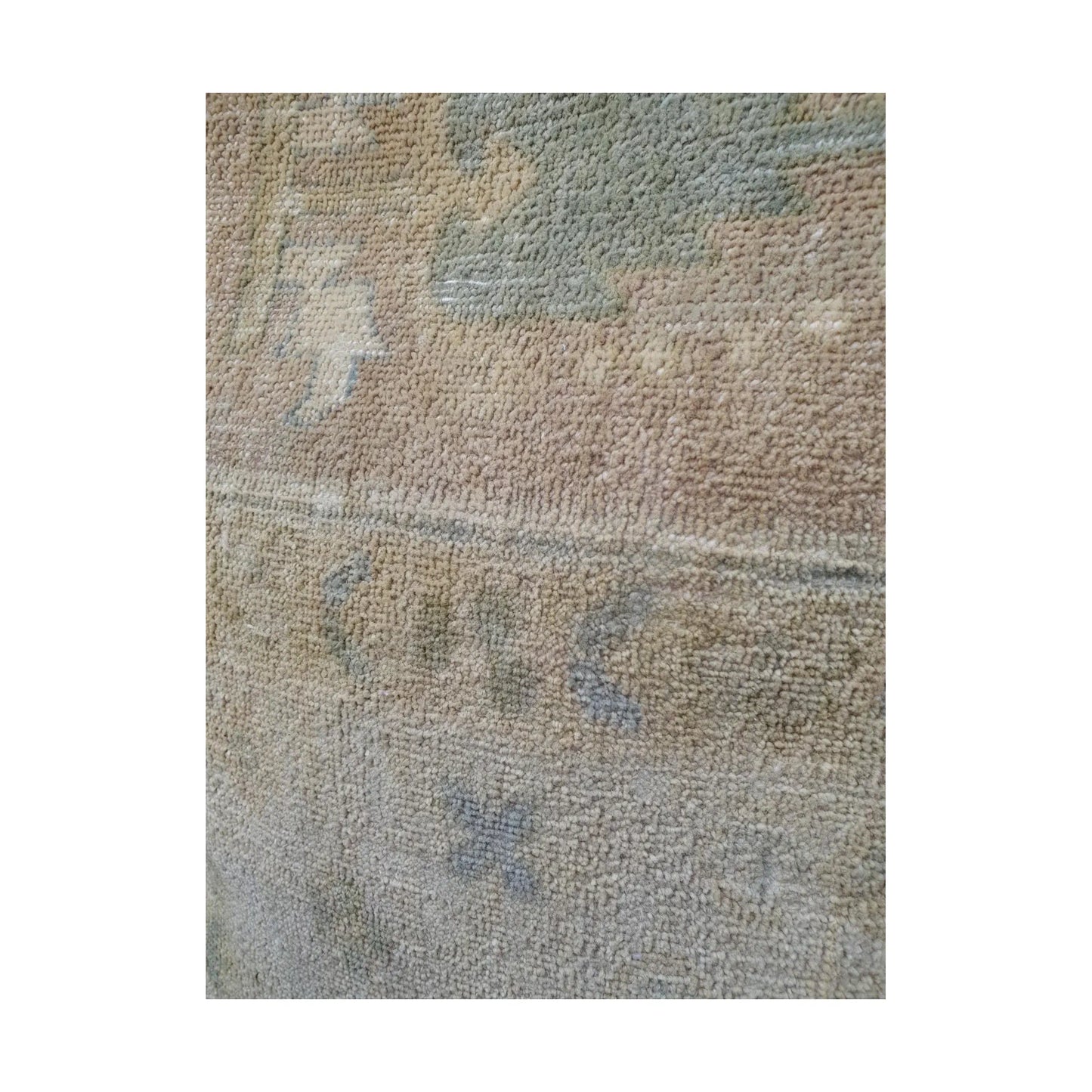 Close-up of muted sage-grey geometric motif and fine lines across the beige wool pile