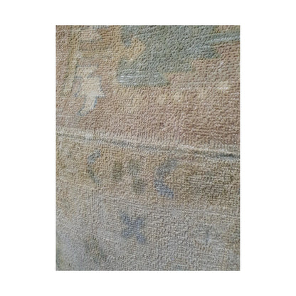 Close-up of muted sage-grey geometric motif and fine lines across the beige wool pile