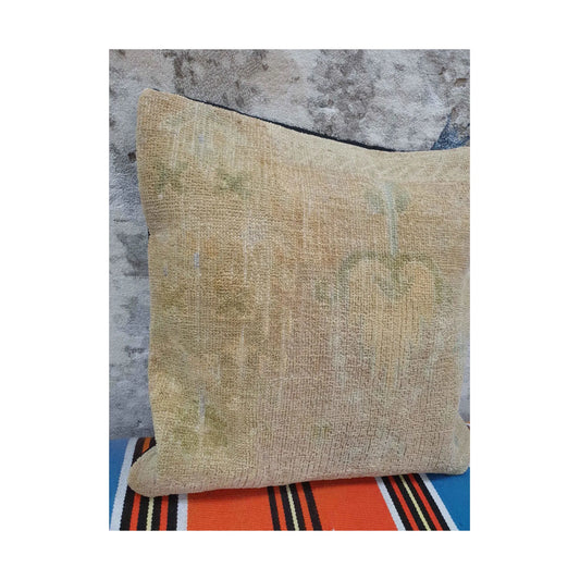 Closer view of beige wool pile showing muted olive-grey floral and linear traces