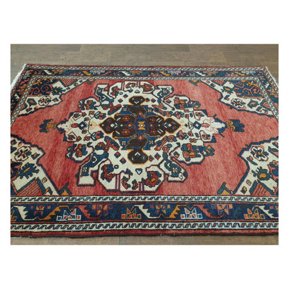 Angled full view of vintage Persian Hamadan rug showing medallion field and border