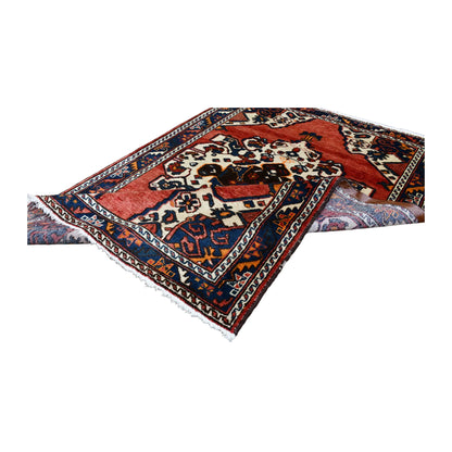 Folded view of vintage Persian Hamadan hand-knotted wool rug showing its medallion field, border and fringe