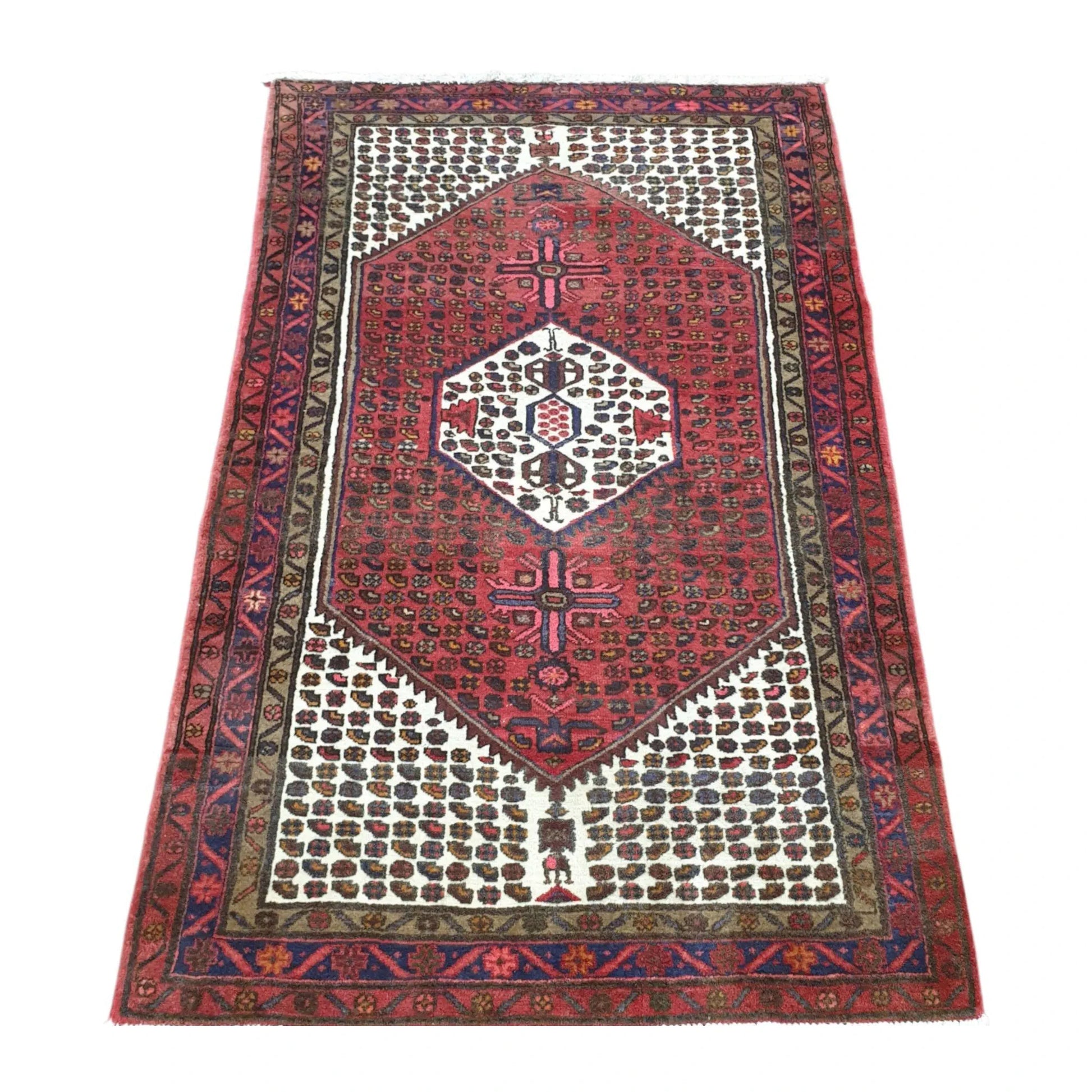 Angled full view of vintage Persian Hamadan rug showing red geometric medallion design