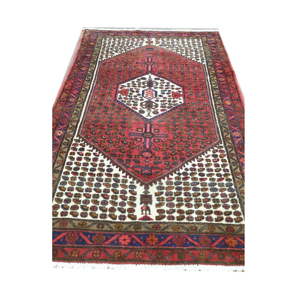 End detail of vintage Persian Hamadan wool rug showing geometric pattern and fringe