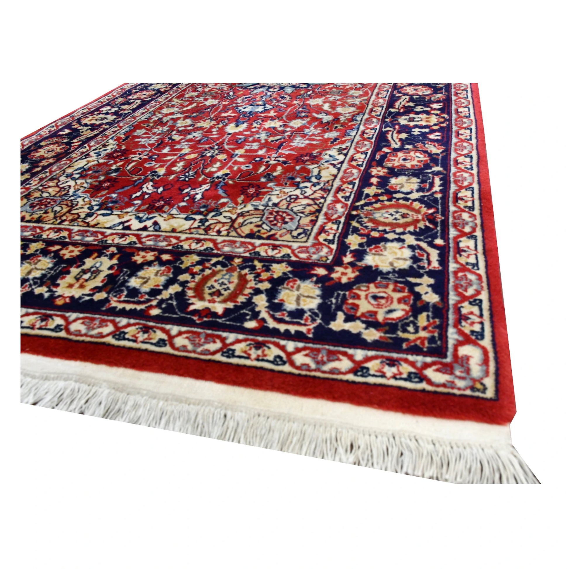 Angled end detail of vintage Kashan runner showing cream fringe, red wool pile and layered navy floral border