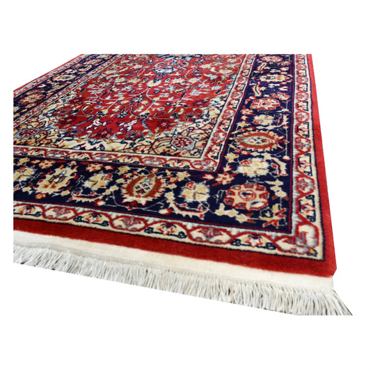 Angled end detail of vintage Kashan runner showing cream fringe, red wool pile and layered navy floral border