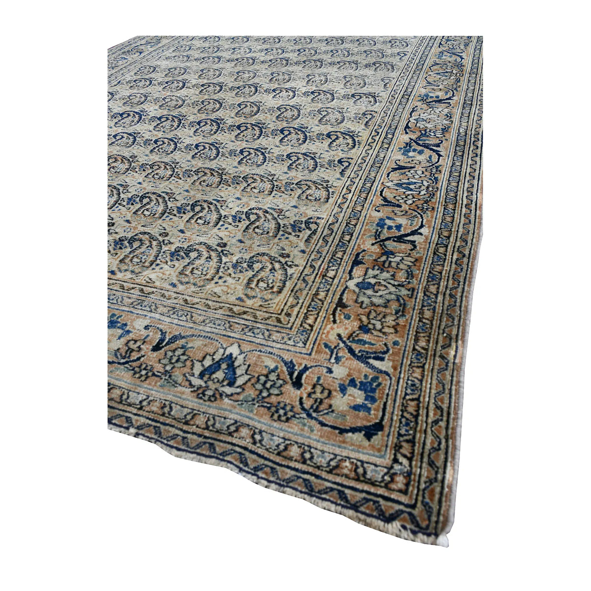 Angled view of Mashad Dorakhash rug showing its repeating boteh field, layered floral borders and short pale fringe
