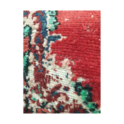 Close-up of the red wool field and partial ivory, navy and green floral motifs