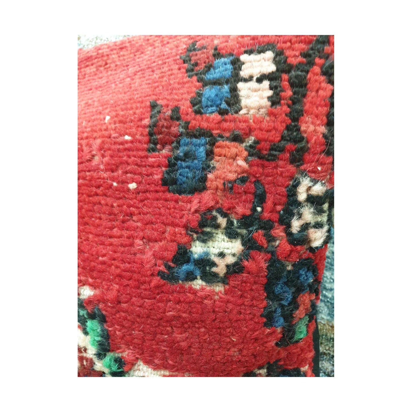 Close-up of red wool pile with navy, ivory and dark-outlined Persian motif fragments