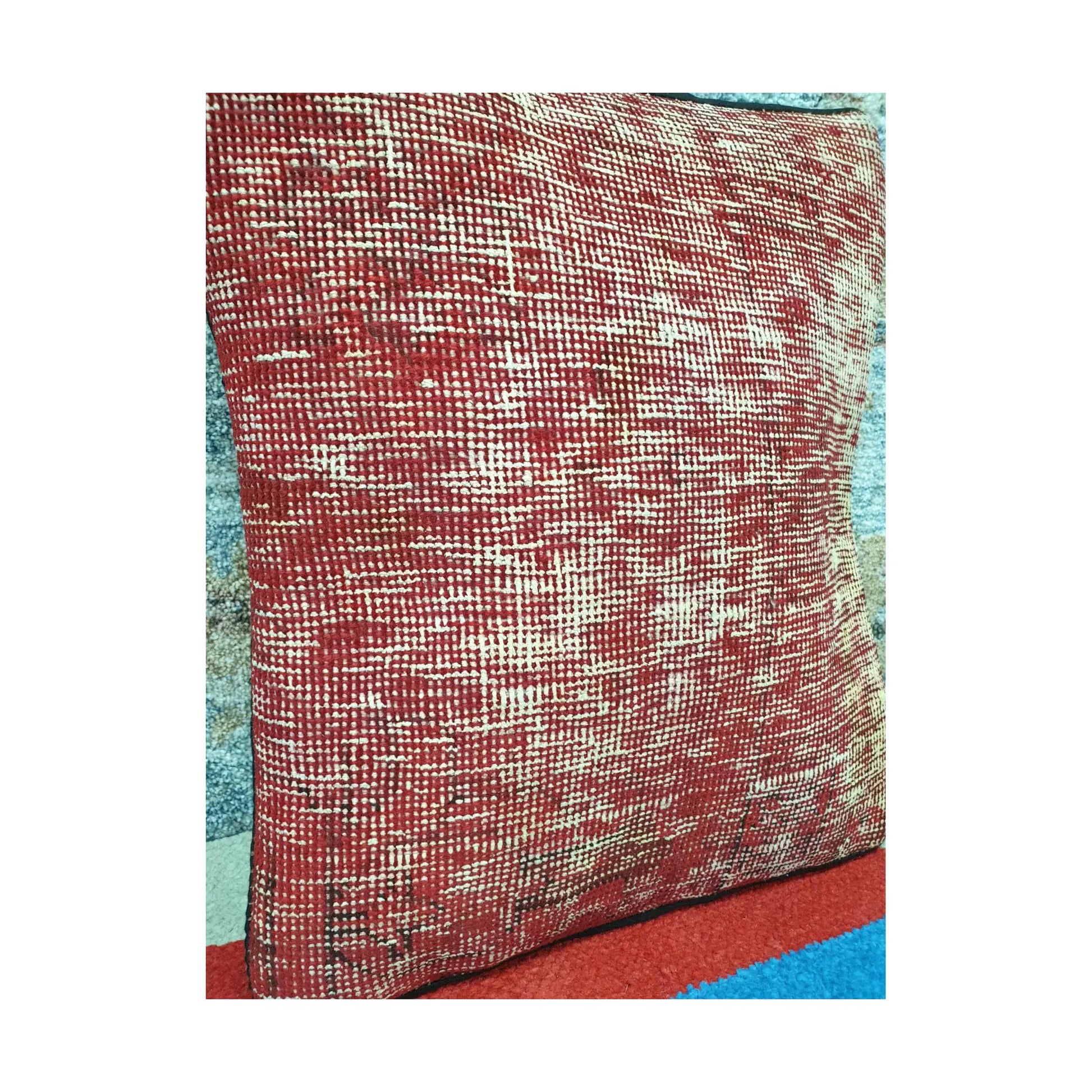 Angled view of warm red wool pile covered with irregular ivory linear traces