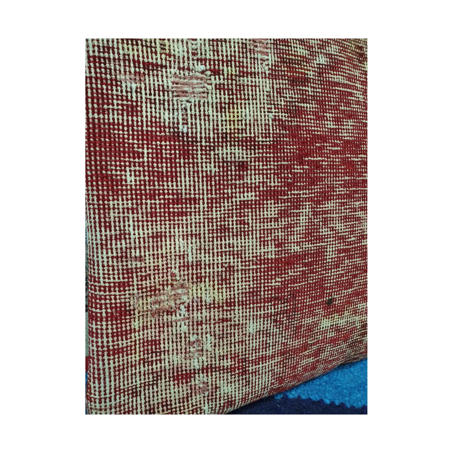 Detailed view of irregular red and ivory crosshatching across the hand-knotted wool pile
