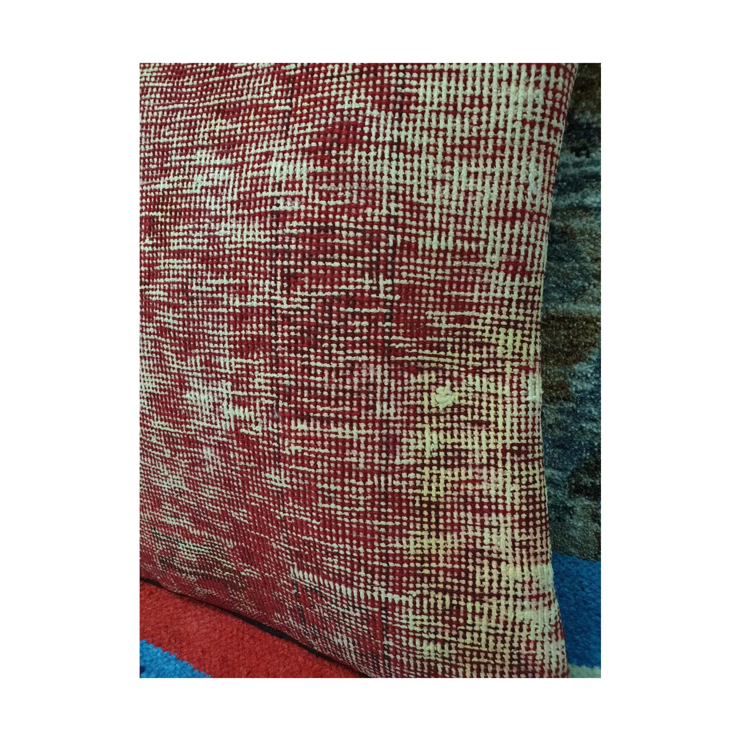 Close-up of dense ivory crosshatching and fragmented geometric lines across the red wool pile